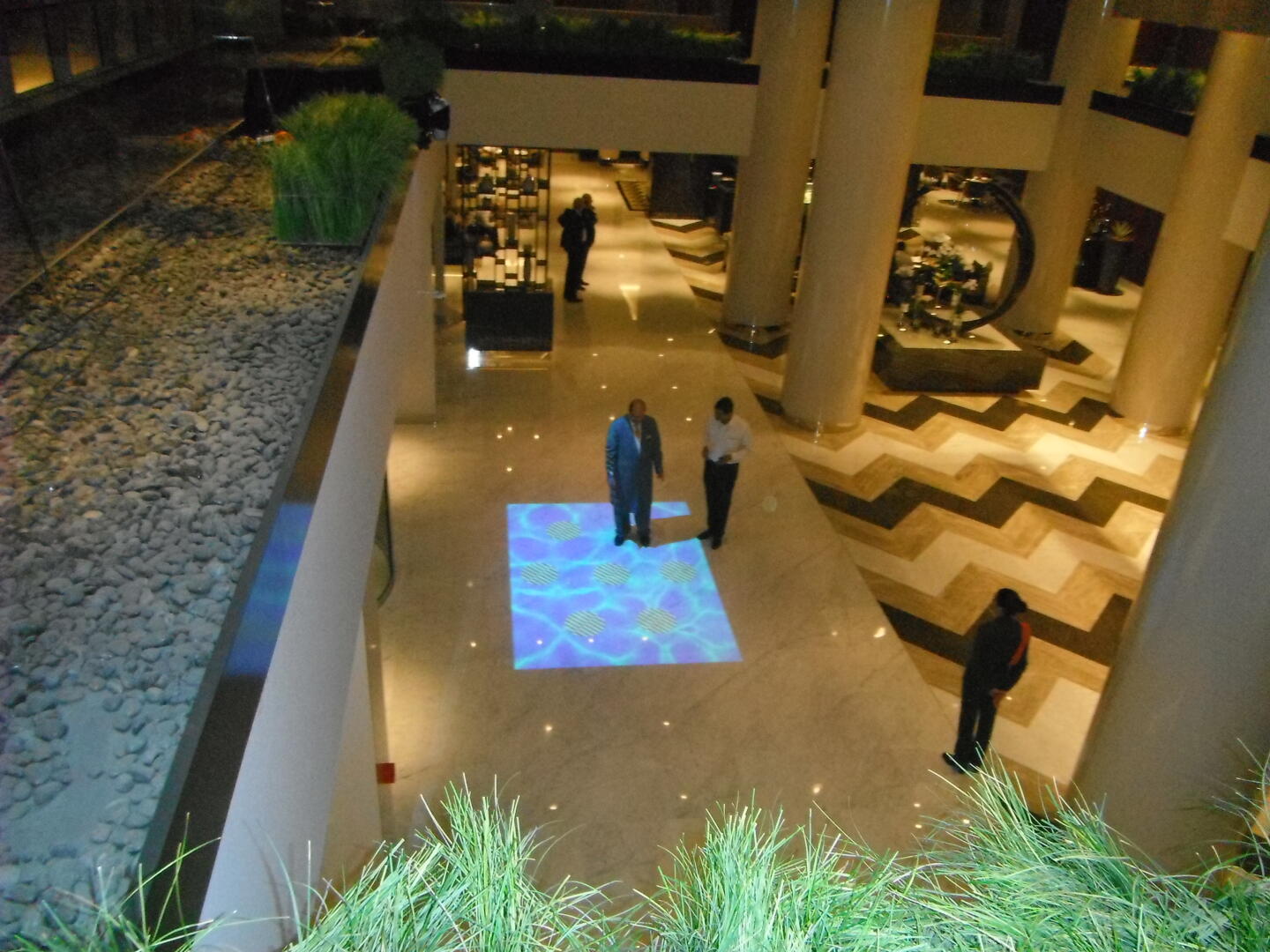Interactive floor projection at Pullman Hotel, Dubai, featuring water ripples and brand logos.