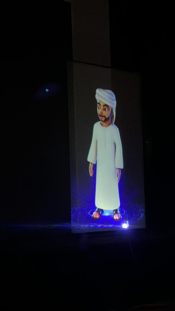 A holographic mascot appearing on stage alongside a Master of Ceremonies at a SEHA event.