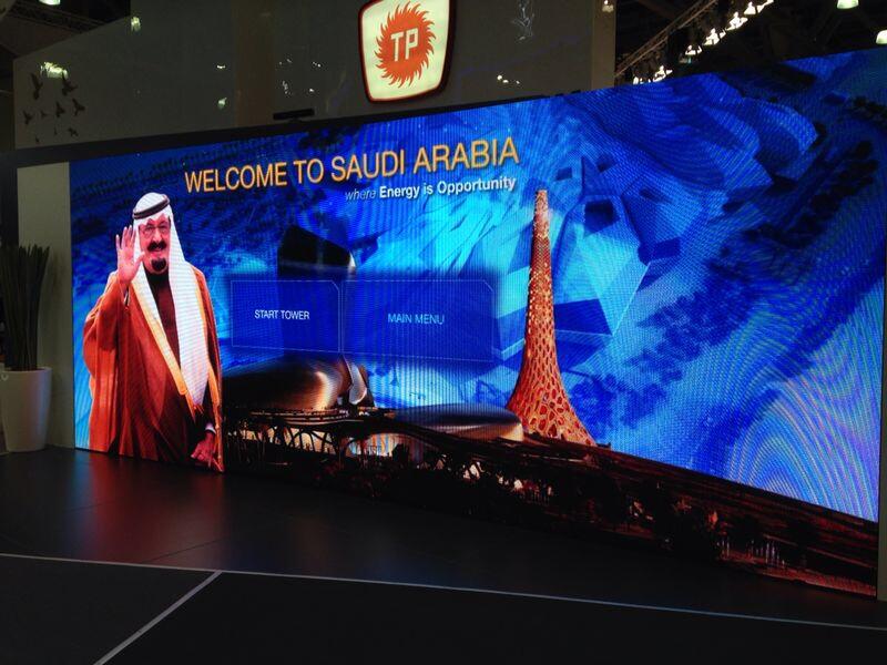 Visitors interacting with a large gesture-controlled video wall at the Turkish Petroleum stand for Saudi Aramco.