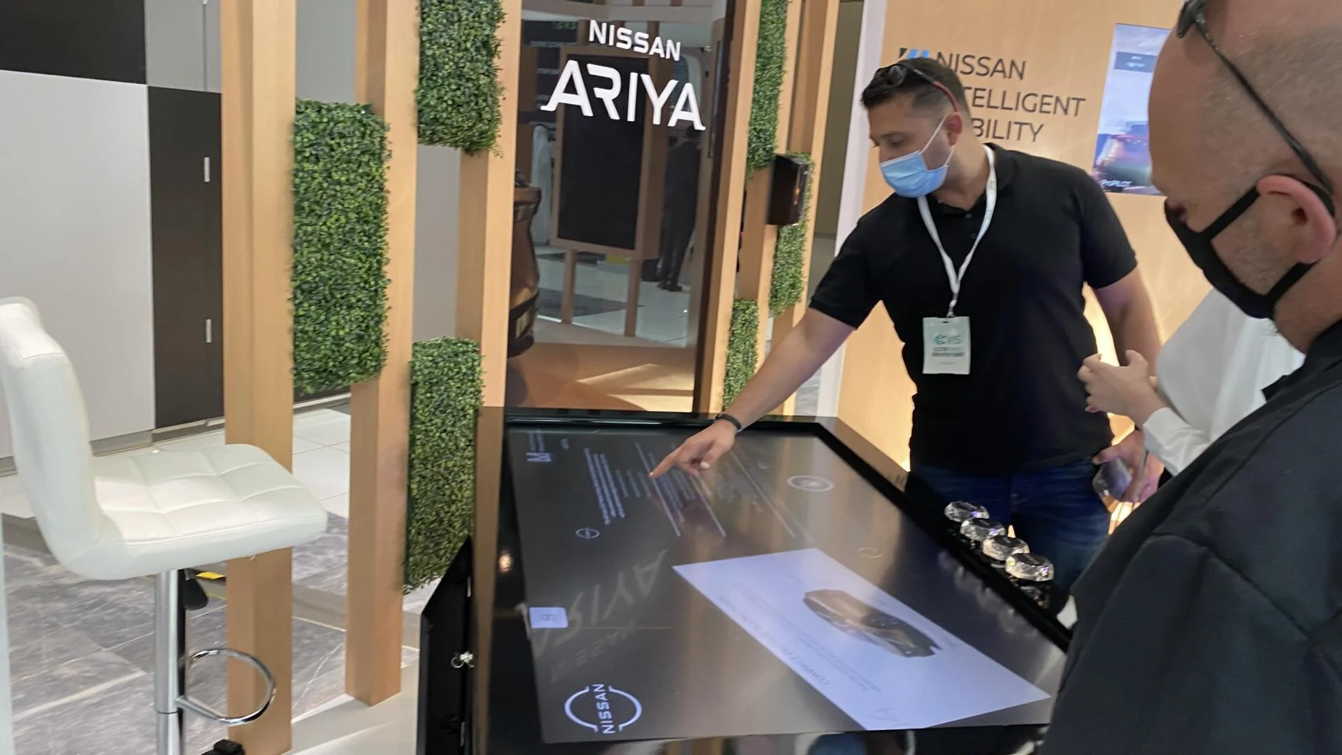 Visitors interacting with Nissan's object recognition table, displaying EV features.