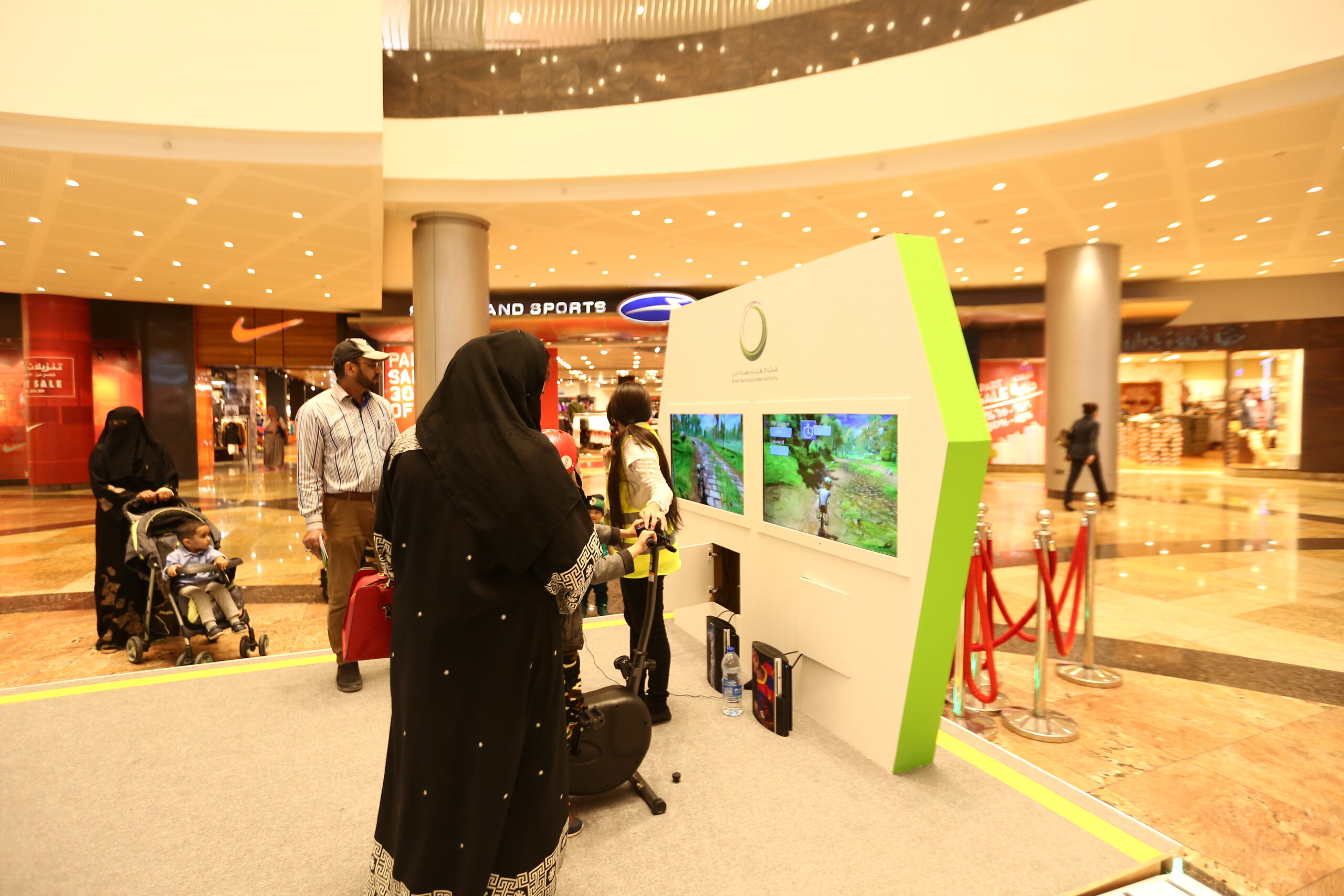 Children participating in a gamified 3D cycling challenge for DEWA Health and Safety Week.
