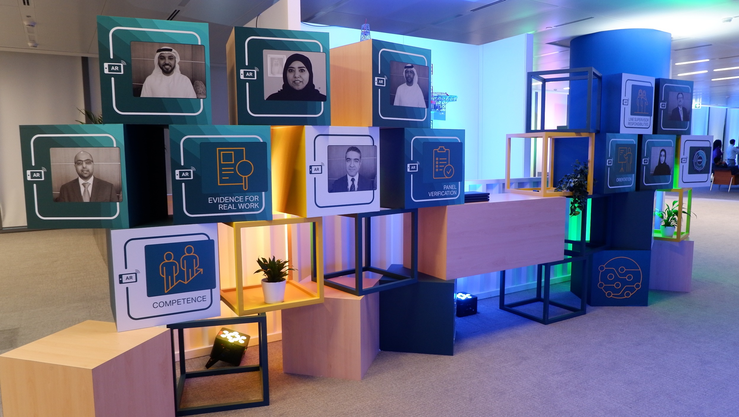 Augmented Reality poster wall at ADNOC YDP event showing interactive video overlays.