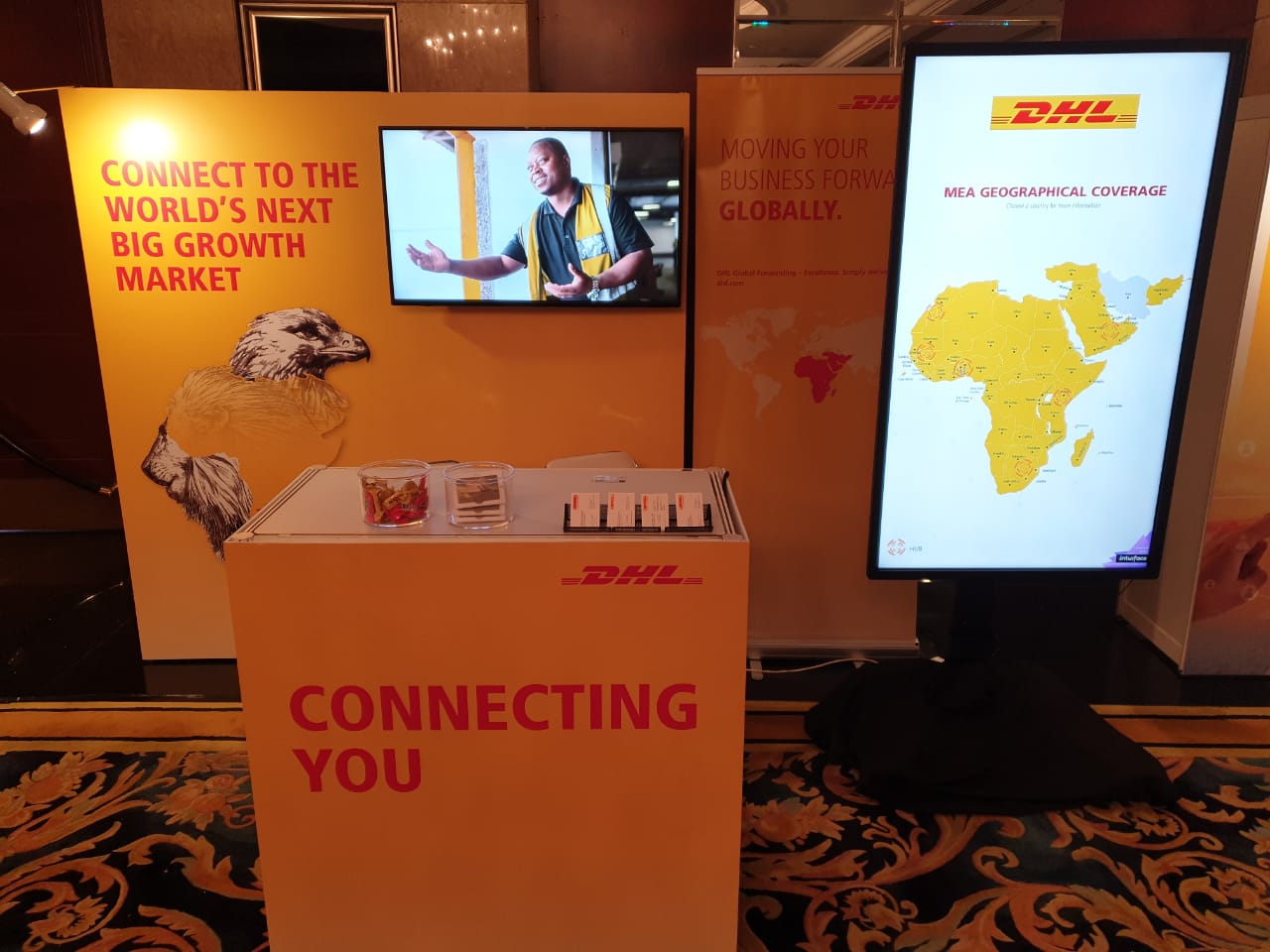 Interactive multi-touch kiosk displaying DHL MEA region map and logistics data.