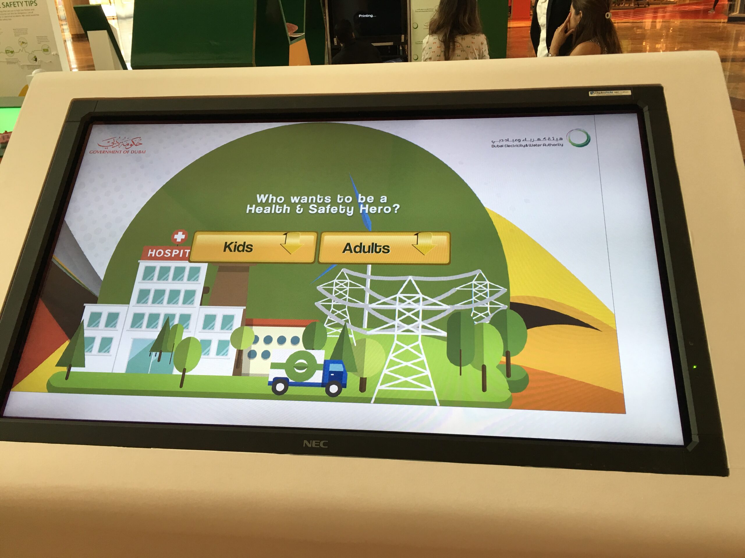 Children interacting with DEWA Health and Safety touchscreen quiz game.