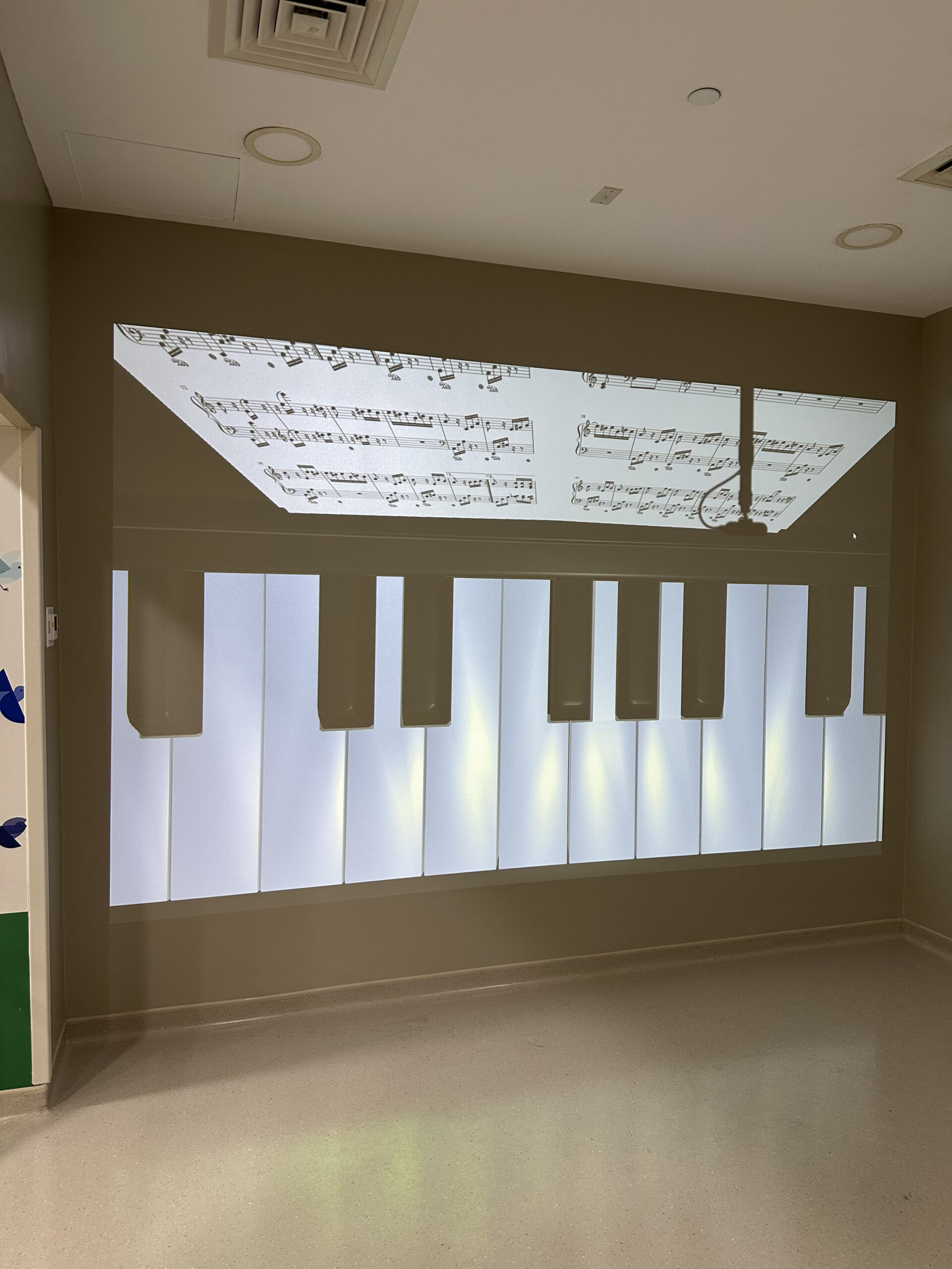 Children playing with an interactive projection wall using physical balls at MediClinic Dubai.