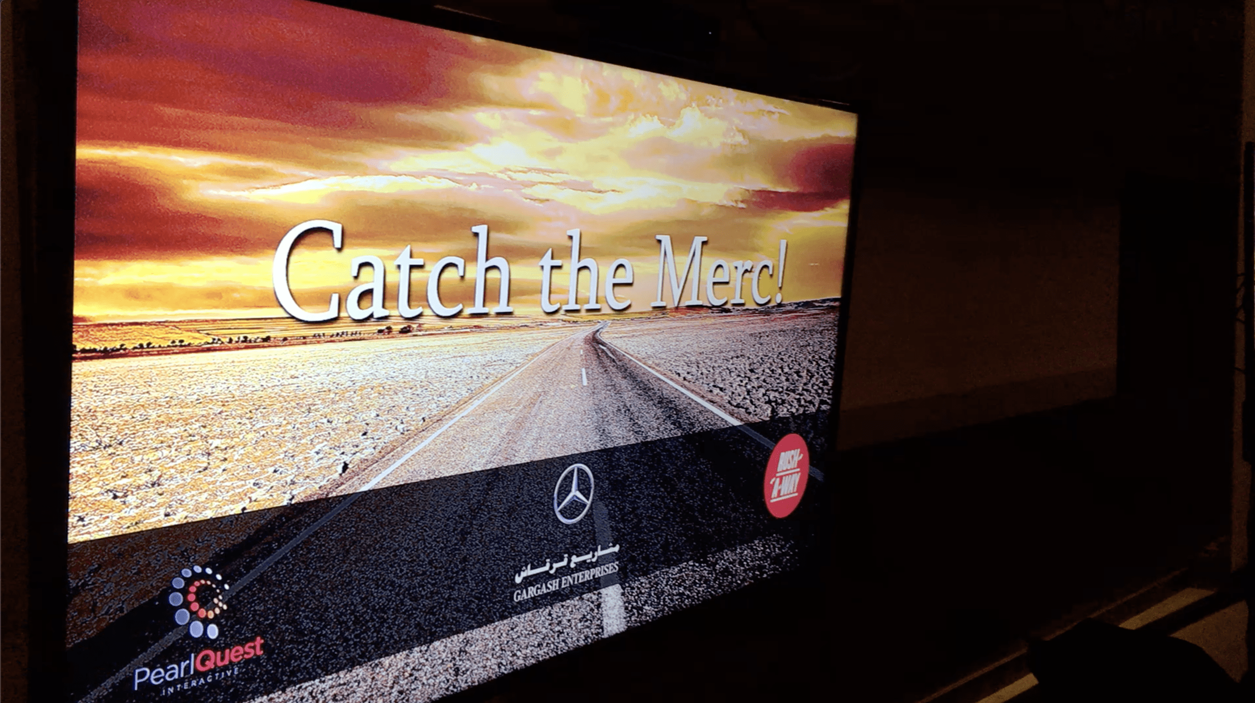 Player using Kinect motion tracking to catch virtual Mercedes cars in a branded dexterity game.